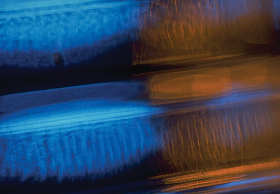Abstract blue and orange light streaks create a dynamic and vibrant visual pattern, conveying motion and energy.