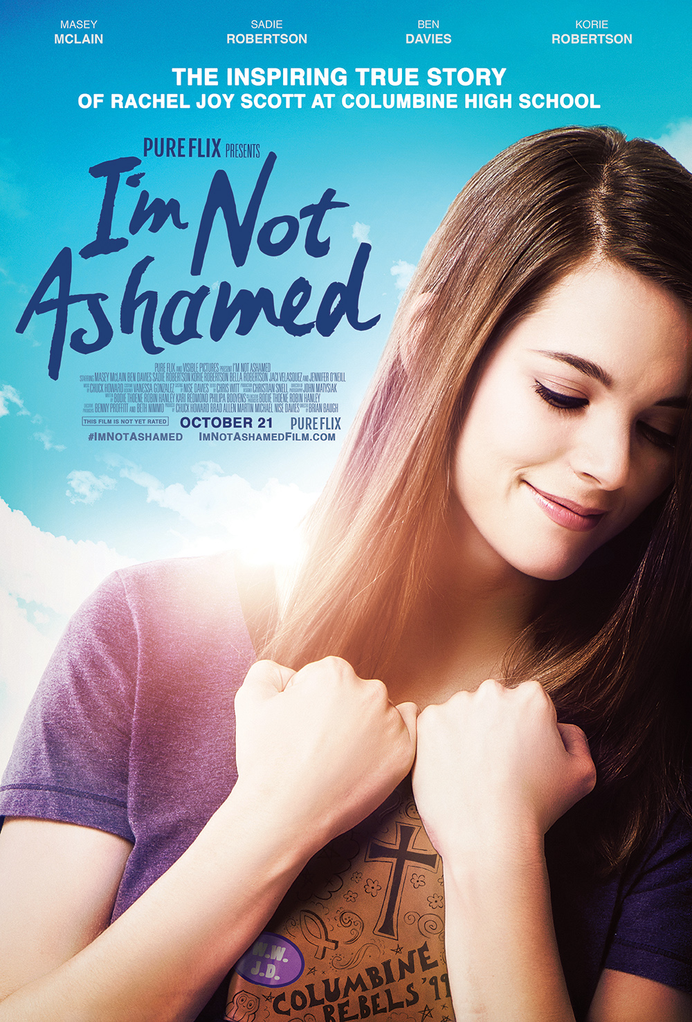 Film poster for I'm Not Ashamed, featuring a smiling woman holding a book with Columbine HS Rebels '99.