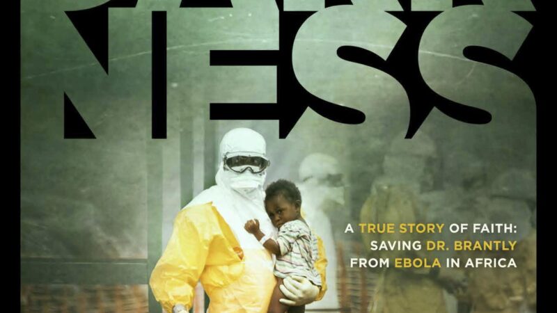 Facing Darkness movie poster: Doctor holding child in protective gear addressing Ebola in Africa. In theaters March 30.
