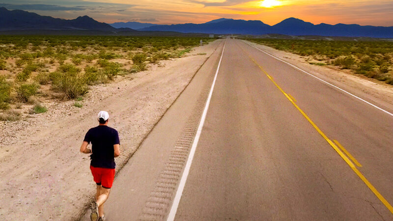 Runner on deserted highway under vibrant sunset, promoting Extraordinary film based on true marriage journey.