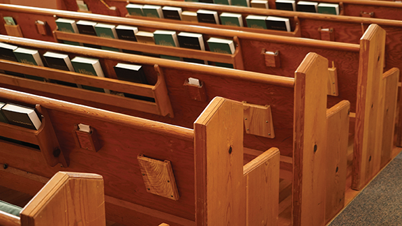 Wooden church pews with hymnals, providing a serene and traditional setting for worship and contemplation.