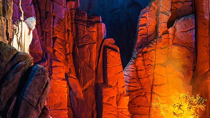 Vibrant theatrical poster for Sight & Sound's Moses performance, featuring dramatic rock formations and burning bush.