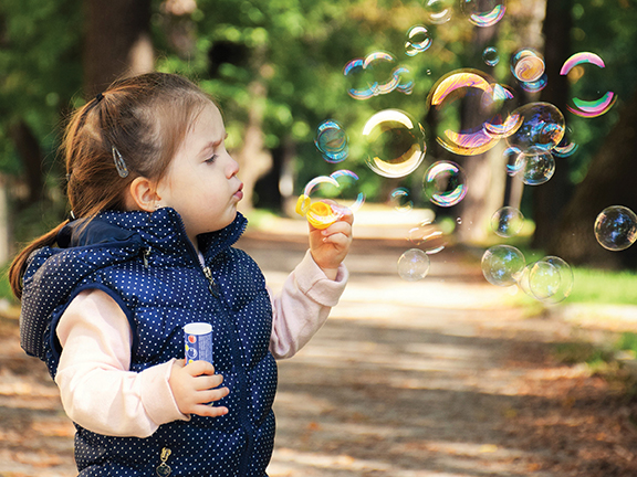 child blowing bubbles
