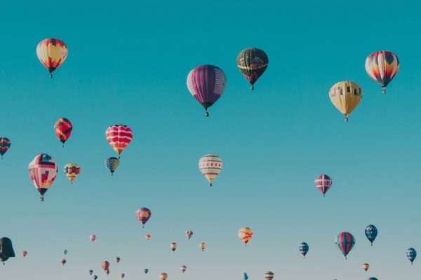 Colorful hot air balloons floating in a clear blue sky, creating a picturesque and serene scene.