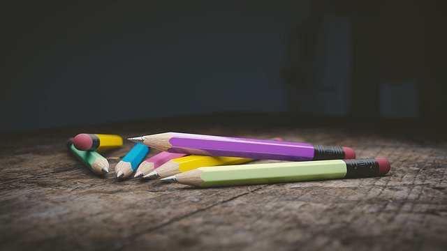 Colorful pencils scattered on a wooden table, highlighting creativity and education.