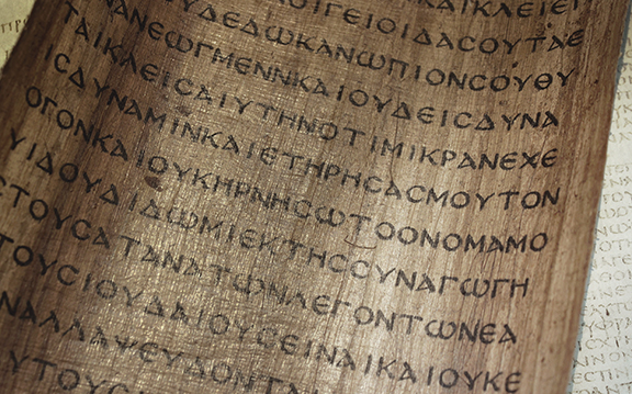 Ancient Greek manuscript with text on aged parchment, featuring classical Greek script and historical writing.