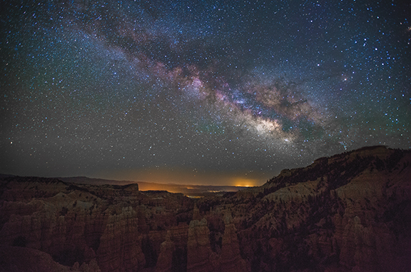 Starry night over Bryce Canyon with Milky Way galaxy, showcasing vibrant stars and rugged rock formations.