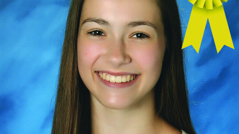 Smiling person with long hair and floral top, awarded third place with a yellow ribbon on a blue background.