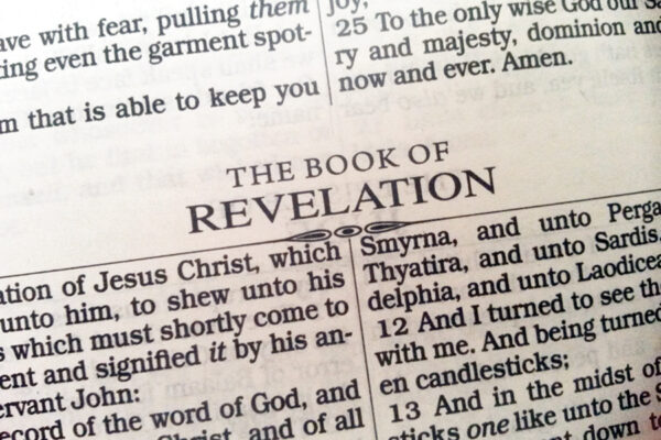 Open Bible page showing heading for the Book of Revelation with text references to Jesus Christ.