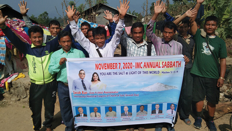 Group of people holding a banner for the IMC Annual Sabbath event, November 7, 2020, in an outdoor setting.
