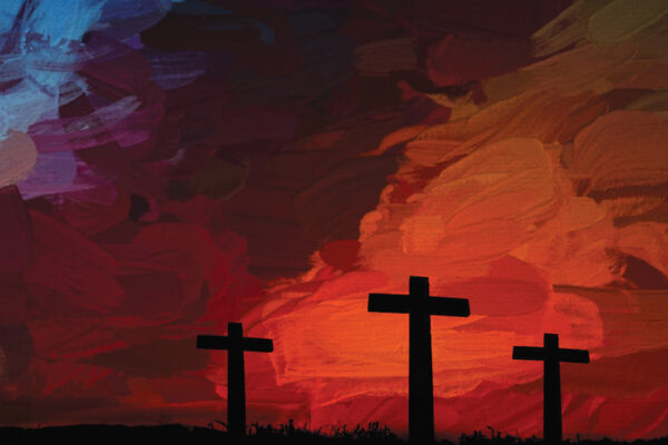 Silhouetted crosses against a vibrant red and blue sunset sky, symbolizing faith and hope.