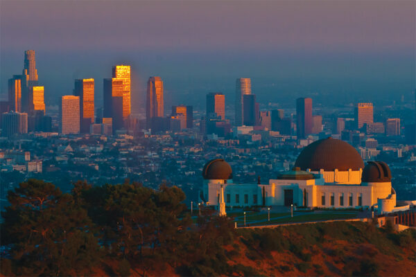 Griffith Observatory overlooking Los Angeles skyline at sunset, showcasing iconic architecture and cityscape views.