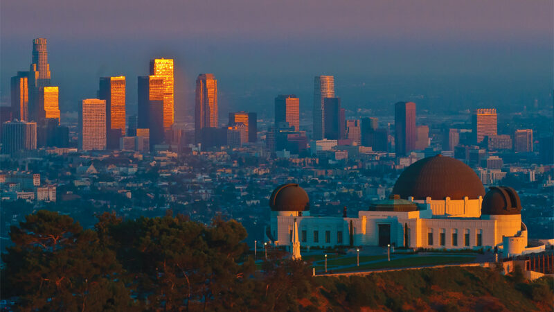 Griffith Observatory overlooking Los Angeles skyline at sunset, showcasing iconic architecture and cityscape views.