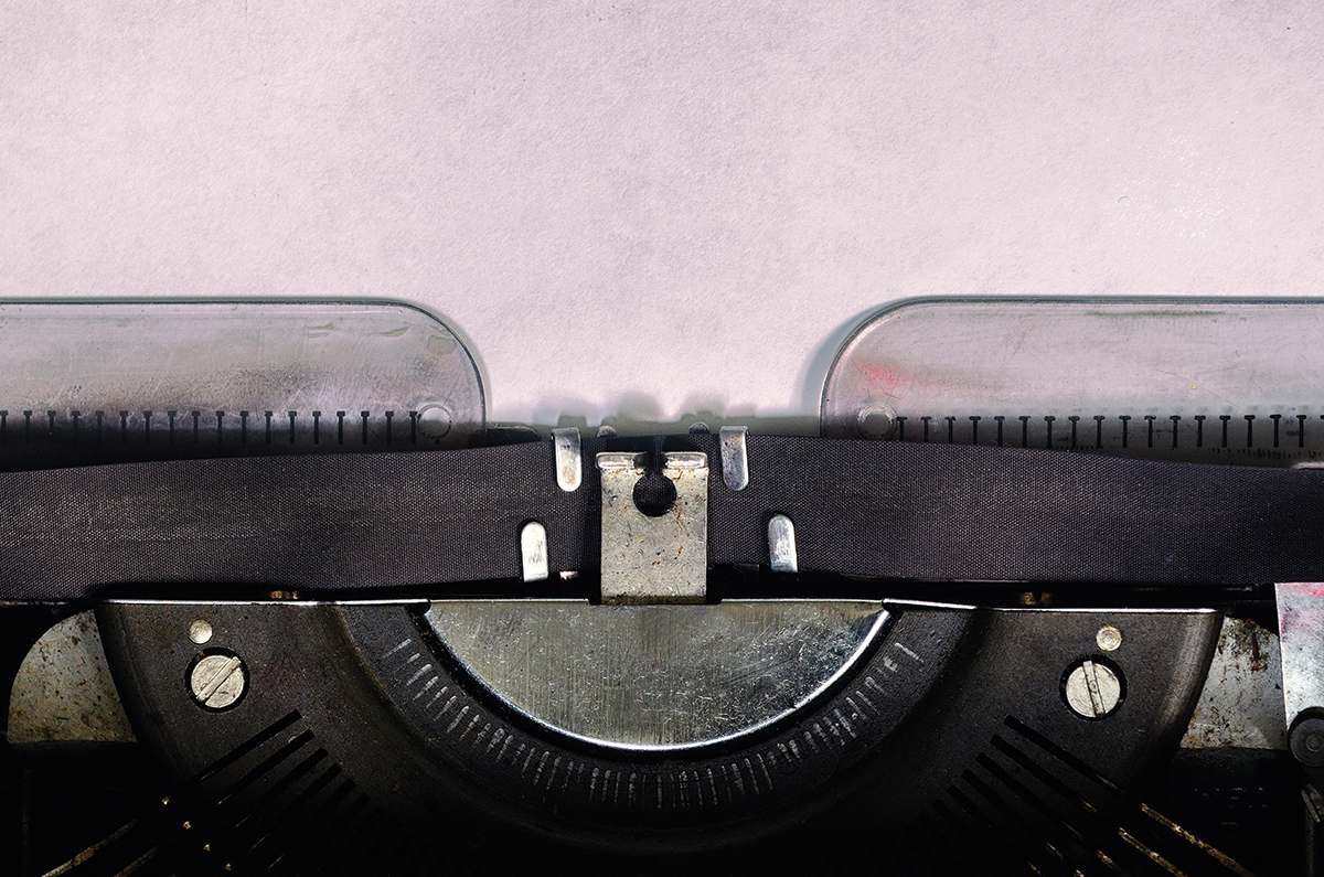 Close-up of vintage typewriter with blank paper, ready for writing.