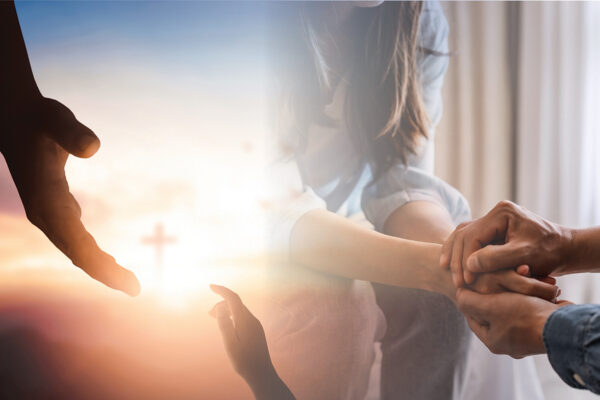 Hands reaching with a cross in the background, symbolizing hope and support in faith.