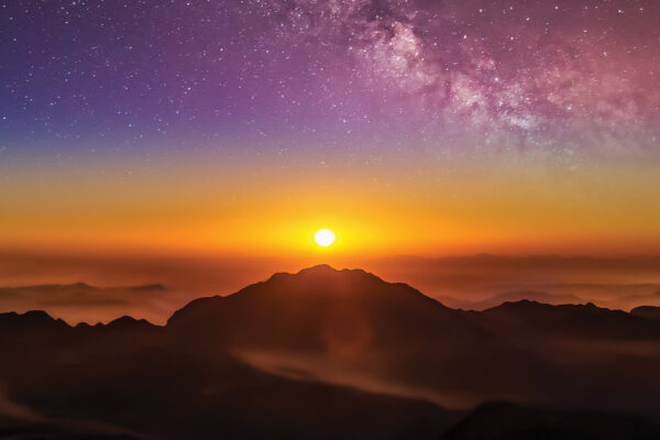 Breathtaking sunrise over misty mountains with vibrant sky and stars. Perfect for nature and travel enthusiasts.