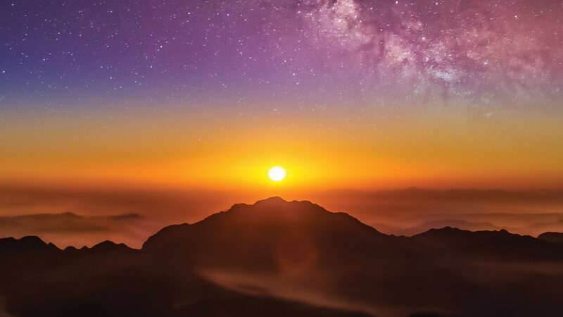 Breathtaking sunrise over misty mountains with vibrant sky and stars. Perfect for nature and travel enthusiasts.