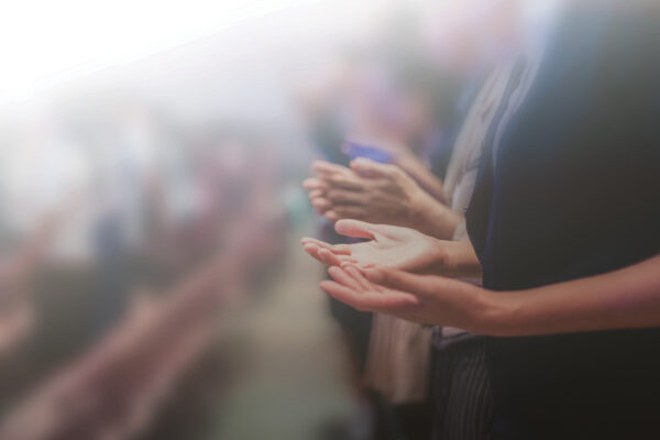 Blurred audience clapping during an event, showcasing engagement and appreciation.