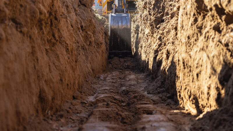 Excavator Digging a Trench for House Foundation
